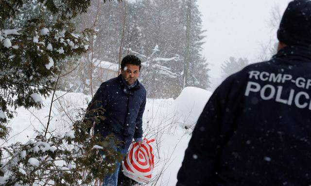 Durch Eis und Schnee: Ein Mann aus dem Sudan, der in Quebec illegal über die Grenze gekommen ist, wird von der kanadischen Polizei in Empfang genommen.