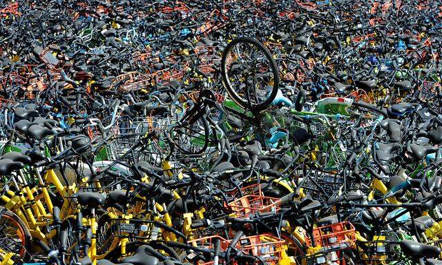 Bicycles of various bike-sharing services are seen at a vacant lot in Wuhan