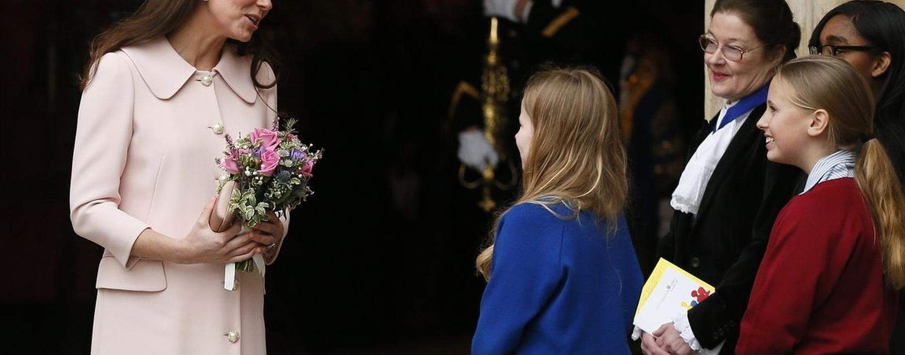 Britain's Catherine Duchess of Cambridge is presented with flowers as she leaves after attending the Commonwealth Observance service at Westminster Abbey in London