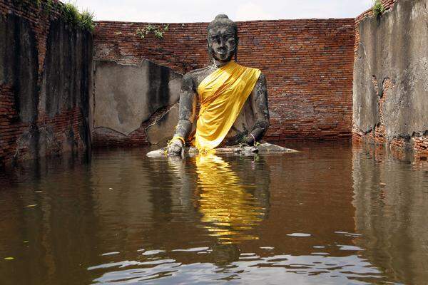 Die Fluten haben schon Schäden im Milliarden-Euro-Beriech angerichtet. Das Wirtschaftswachstum werde in diesem Jahr darunter leiden, sagen die Behörden.Eine Buddha-Statue im Skulpturenpark von Ayutthaya.