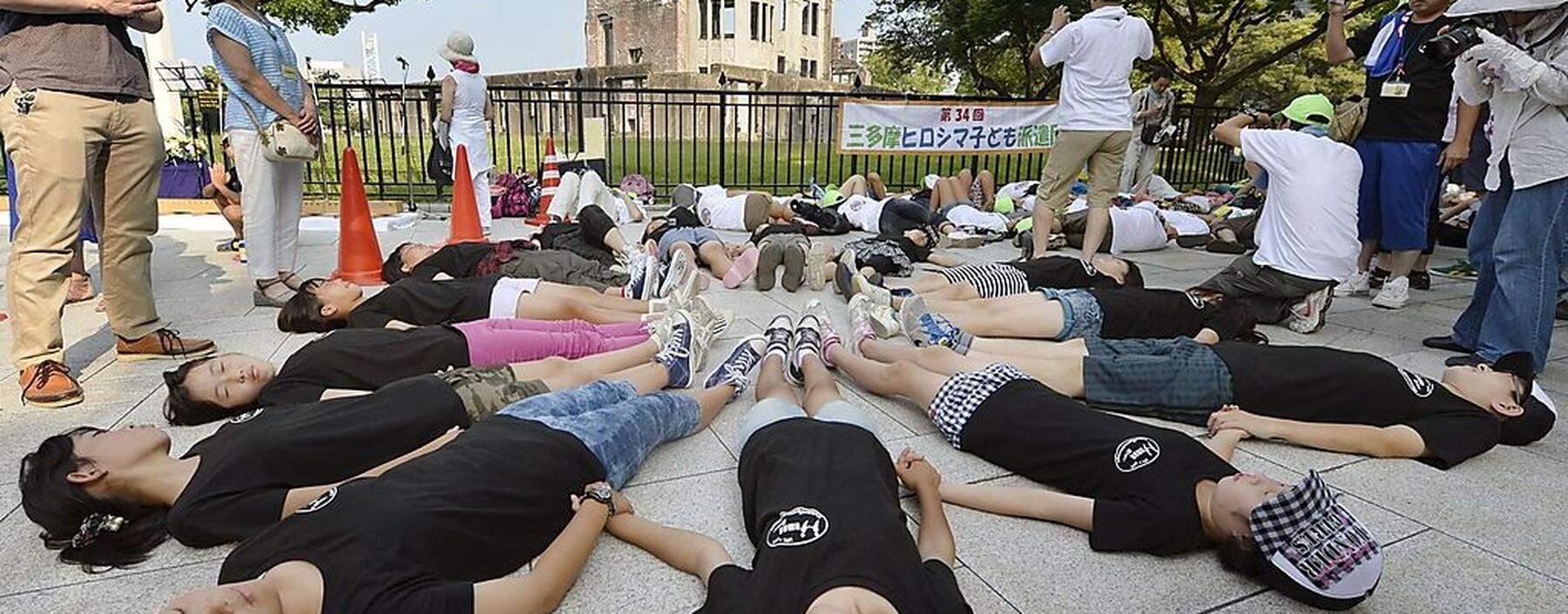 A woman reacts after praying for victims in front of the cenotaph for victims of the 1945 atomic bombing, at Peace Memorial Park in Hiroshima