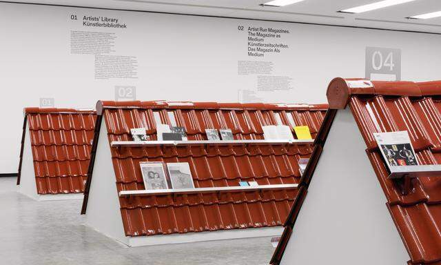 Drei Ziegeldächer dienen in der Kunsthalle als Regale für Hunderte Kunst-Publikationen. Überfliegen wäre eine Assoziation dazu.