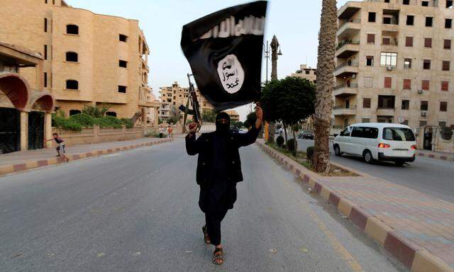 A member loyal to Islamic State waves a flag in Raqqa