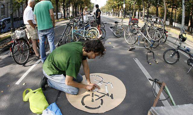 A man draws a bicycle sign onto Vienna's closed Ringstrasse street to celebrate World Car Free Day in Vienna