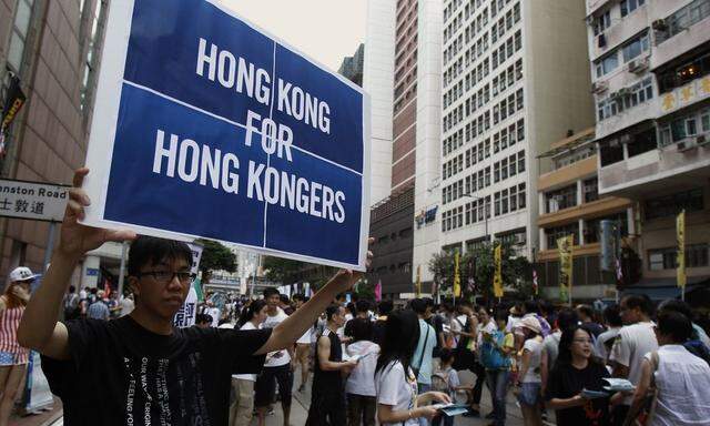 A protester carries a placard during a mass protest demanding universal suffrage in Hong Kong