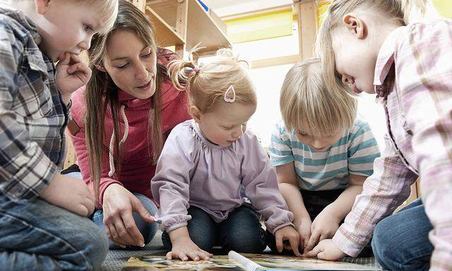 Female educator and four kids looking at picture book mit_2003_01363