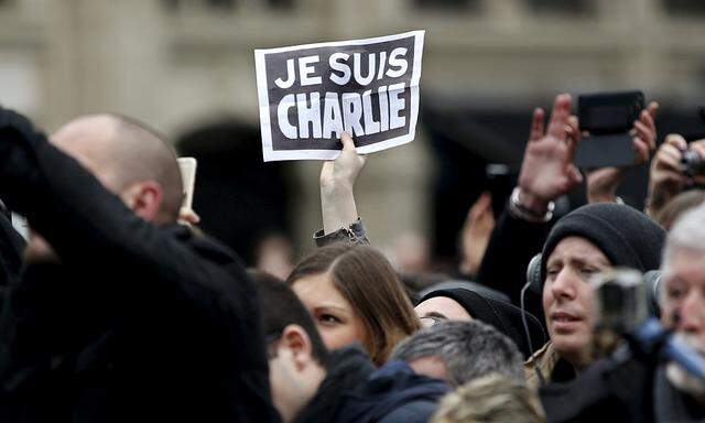 Person holds up a sign during a ceremony at Place de la Republique square to pay tribute to the victims of last year´s shooting at the French satirical newspaper Charlie Hebdo, in Paris