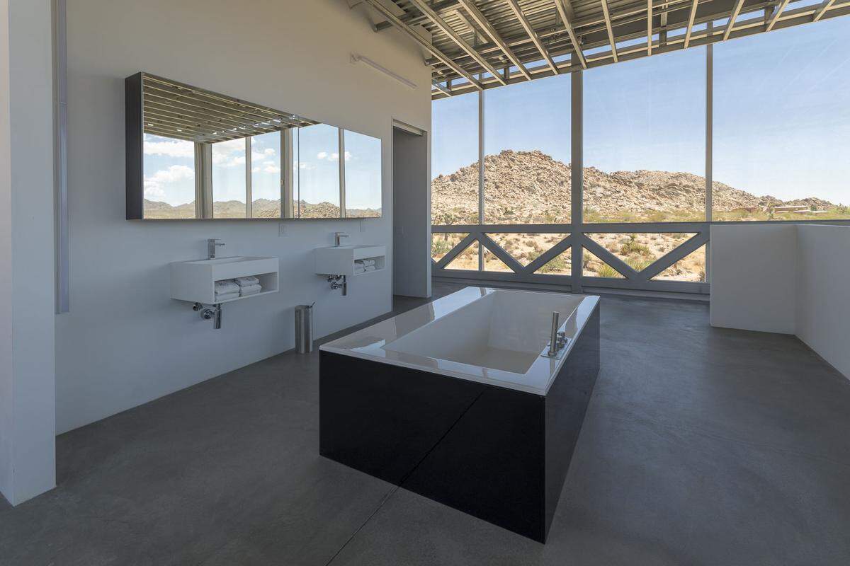 . . . sowie ein weiteres Badezimmer, deren ebenfalls durchgehend verglaste Wände teilweise komplett zur Wüstenlandschaft geöffnet werden können.