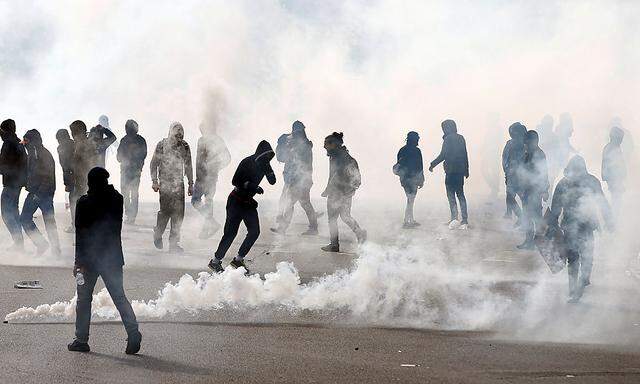 Maskierte Jugendliche protestieren gegen Hollande.
