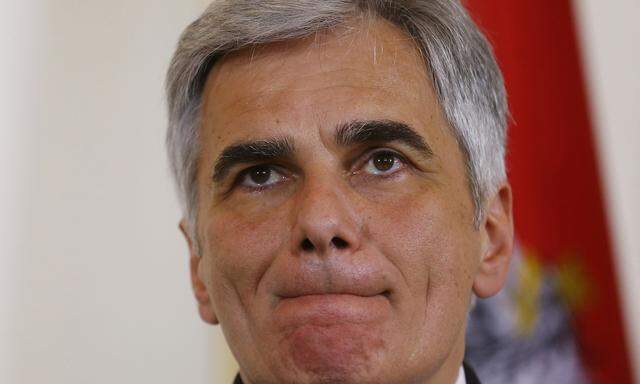 Austria´s Chancellor Faymann listens during a news conference in Vienna