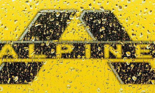 Alpine Bau logo is pictured through raindrops on a window in Vienna