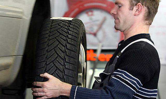 ** ARCHIV ** Ein Mechaniker wechselt die Reifen eines Autos in einer Werkstatt in Dresden am 7. Novem