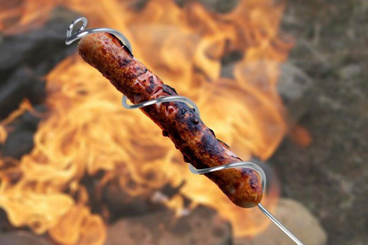 Hier wird die Lagerfeuer-Wurst nicht gespießt, sondern in das gebogene Esschert-Design-Metall "eingefädelt", so trocknet sie nicht aus.