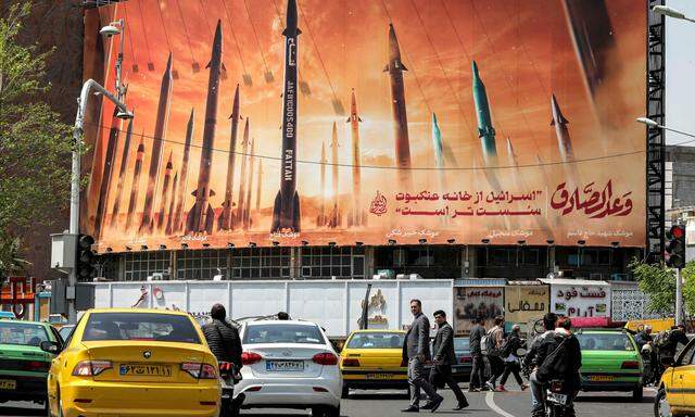 Ein Bild vom 15. April 2024 auf dem Valiasr-Platz im Zentrum von Teheran. Auf Arabisch steht auf einem Plakat: „das Versprechen des ehrlichen Menschen“ und auf Persisch „Israel ist schwächer als ein Spinnennetz“.