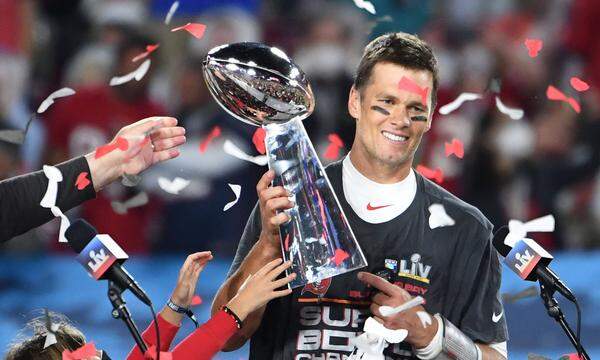 Tampa Bay Buccaneers quarterback Tom Brady stands with one of his children as he is presented the Vince Lombardi Trophy 