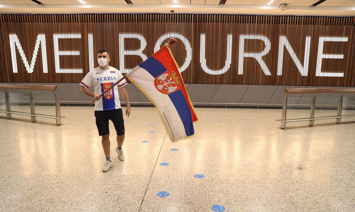 A Serbian fan waits for Novak Djokovic at Melbourne Airport
