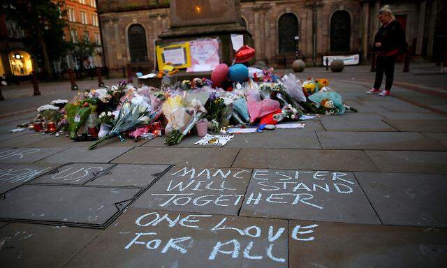 A woman looks at flowers for the victims of the Manchester Arena attack in central Manchester