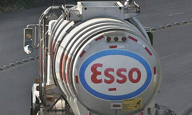 A public bus passes a gasoline distribution truck owned by Esso Standard Oil as it leaves a refinery 