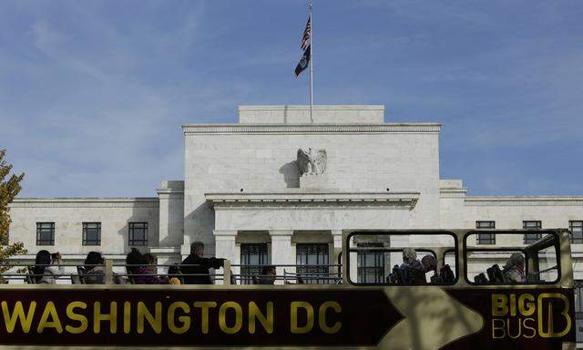 A tour bus passes the United States Federal Reserve Board building in Washington