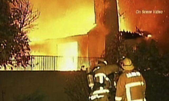 This image from video shows firefighters outside a blazing house in Covina, Calif., late Wednesday, D