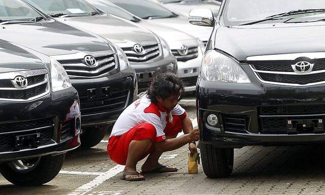 File photo of a worker conducting final checks on the wheels of a Toyota car before handing it over to a customer at the Toyota Astra showroom in Jakarta