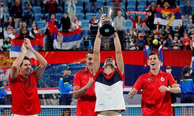 Novak Djokovic jubelt mit Pokal und Kollegen