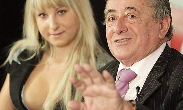 Austrian businessman Lugner gestures next to his girlfriend Anastasia during a news conference in Vie