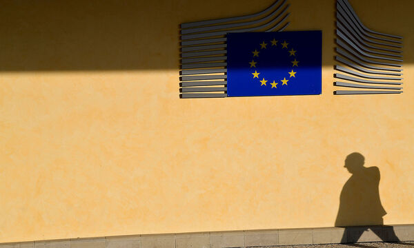 FILE PHOTO: The shadow of a worker is seen beside the EU Commission building in Brussels, Belgium