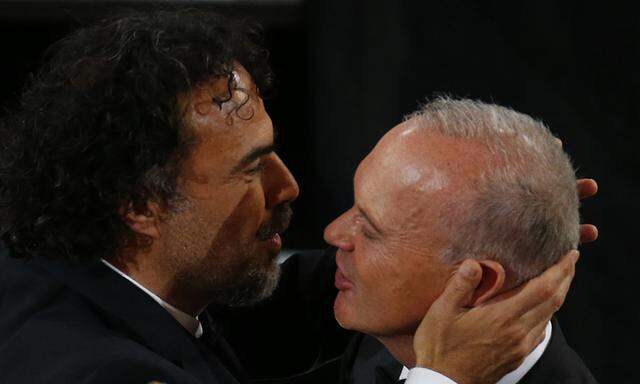Director Alejandro Inarritu is congratulated by actor Michael Keaton as he walks to accept the Oscar for Best Director his film ´Birdman´ at the 87th Academy Awards in Hollywood, California