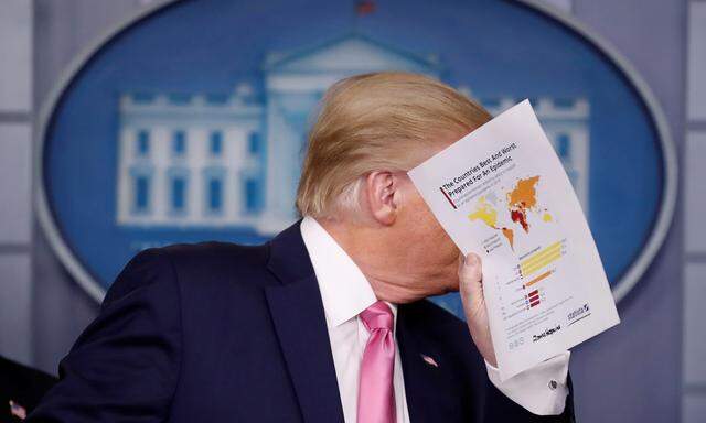 Der US-Präsident bei einer Pressekonferenz zur Corona-Krise im Weißen Haus mit Datenmaterial in der Hand.