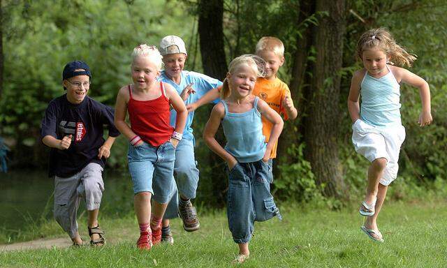 Kinder laufen ueber eine Wiese