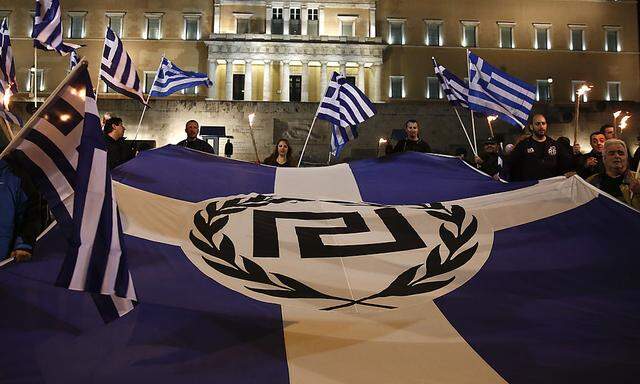 Supporters of Greece´s far-right Golden Dawn party protest around a flag during a rally at central Syntagma square in Athens
