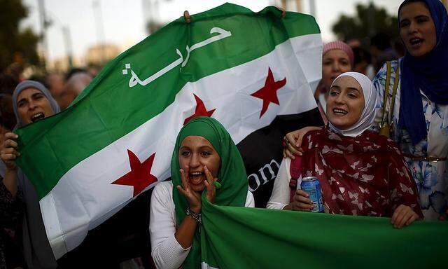 Frauen halten die Fahne der syrischen Opposition hoch.