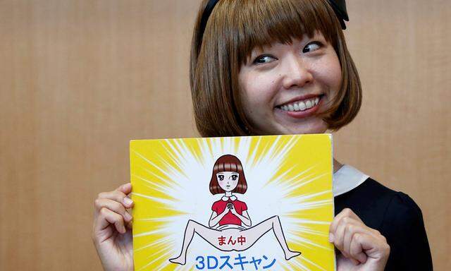 Japanese artist Megumi Igarashi, known as Rokudenashiko, holds her artwork after a news conference following a court appearance in Tokyo