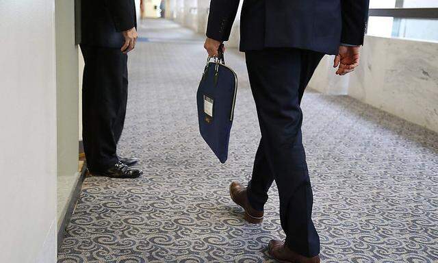 A U.S. Senate Intelligence Committee staff member enters the committee's offices with a secure attache case on Capitol Hill in Washington