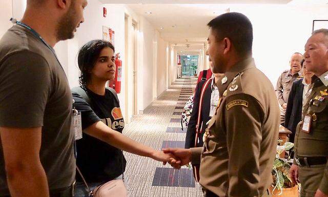 Rahaf Mohammed al-Qunun im Gespräch mit einem thailändischen Behördenvertreter in einem Hotel am Flughafen in Bangkok.