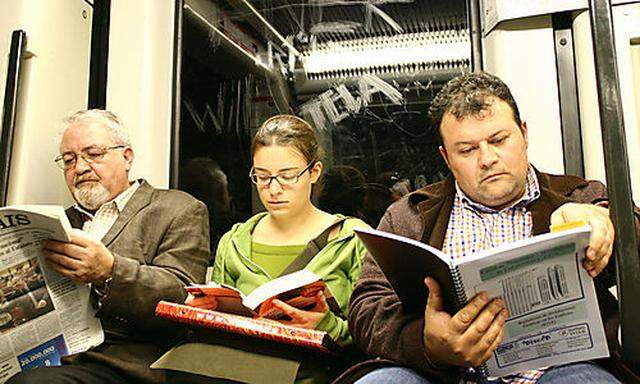Lesende Personen in der U-Bahn