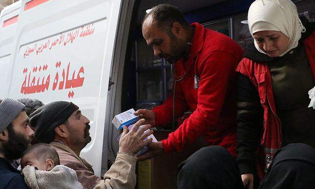 Syrian Red Crescent volunteers give medical supplies to civilians in Ghouta