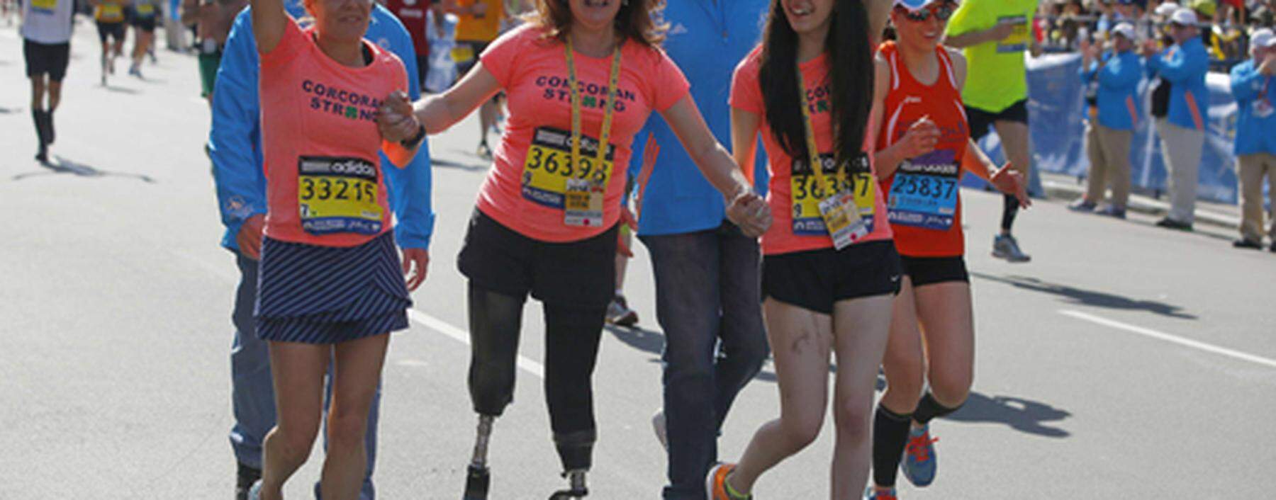 2013 Boston Marathon survivors Celeste Corcoran and her daughter Sydney finish the race with Acabbo, who ran the 118th Boston Marathon, in Boston