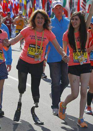 2013 Boston Marathon survivors Celeste Corcoran and her daughter Sydney finish the race with Acabbo, who ran the 118th Boston Marathon, in Boston