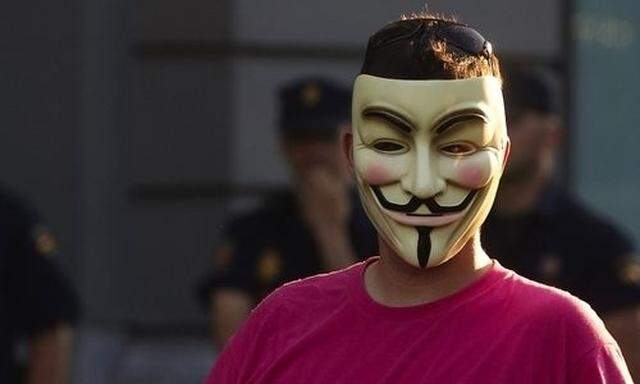 A demonstrator wearing an Anonymous group mask attends an assembly against the Euro Pact and the 