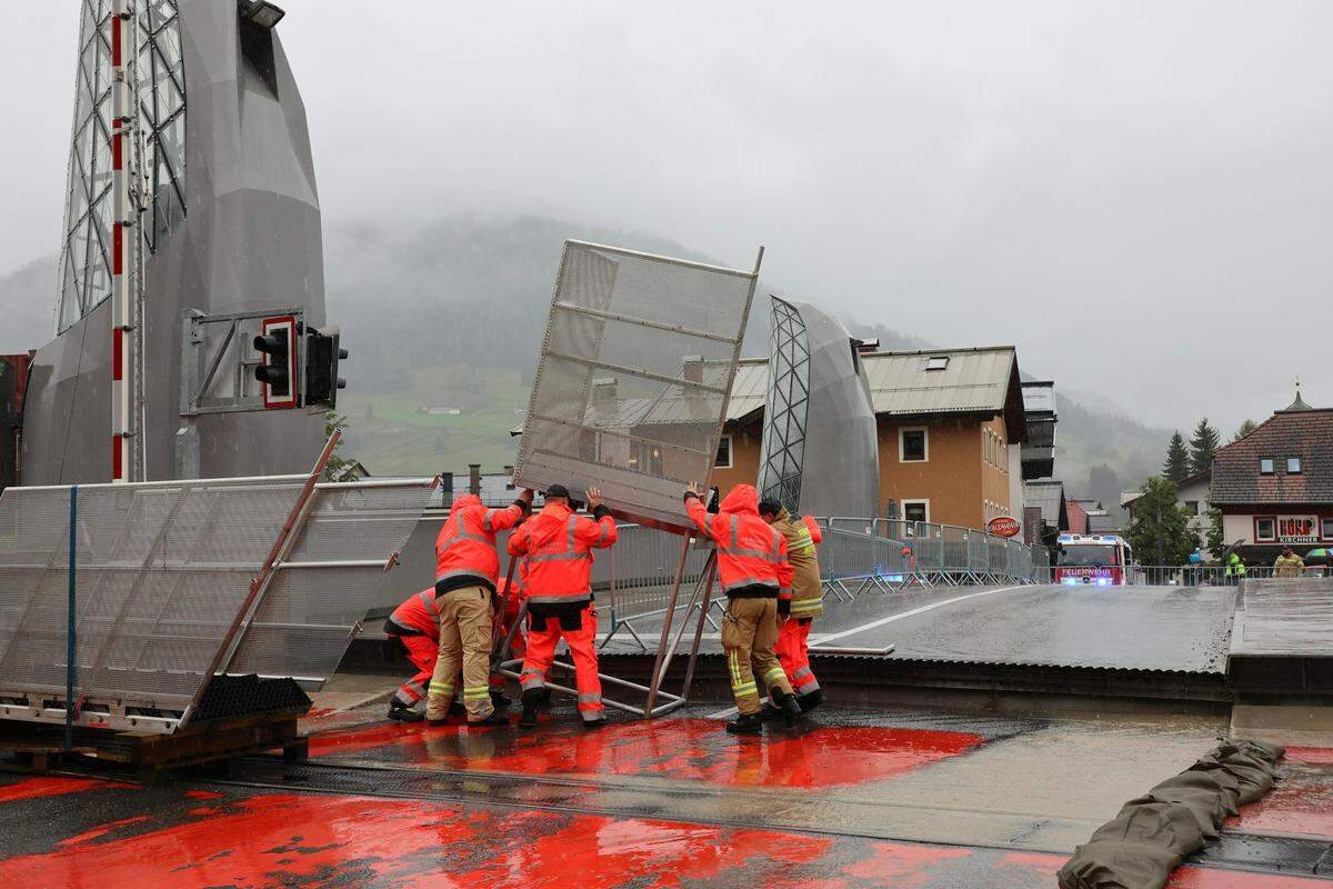 Einsatzkräfte der Feuerwehr beim Aufbau des mobilen Hochwasserschutzes an der Hubbrücke in Mittersill 