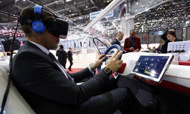 An employee sits inside a virtual reality connected car cockpit built by Segula Technologies during the first press day ahead of the 85th International Motor Show in Geneva