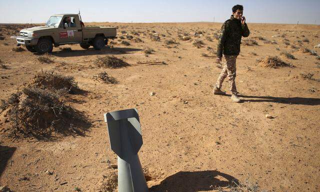 Ein libyscher Kämpfer spaziert nach einem Luftangriff an einem Blindgänger vorbei. Die Bürgerkriegswirren in dem nordafrikanischen Land verstärkten den Einfluss extremistischer Kräfte.
