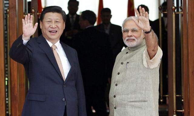 India's PM Modi and China's President Xi wave before their meeting in Ahmedabad