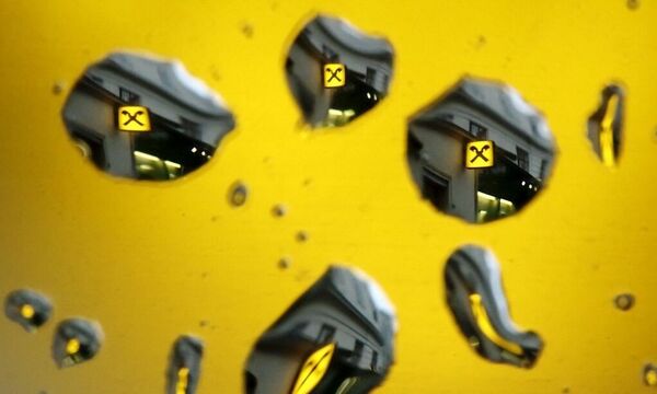 File photo of the logo of Raiffeisen bank seen through raindrops at a branch office in Vienna