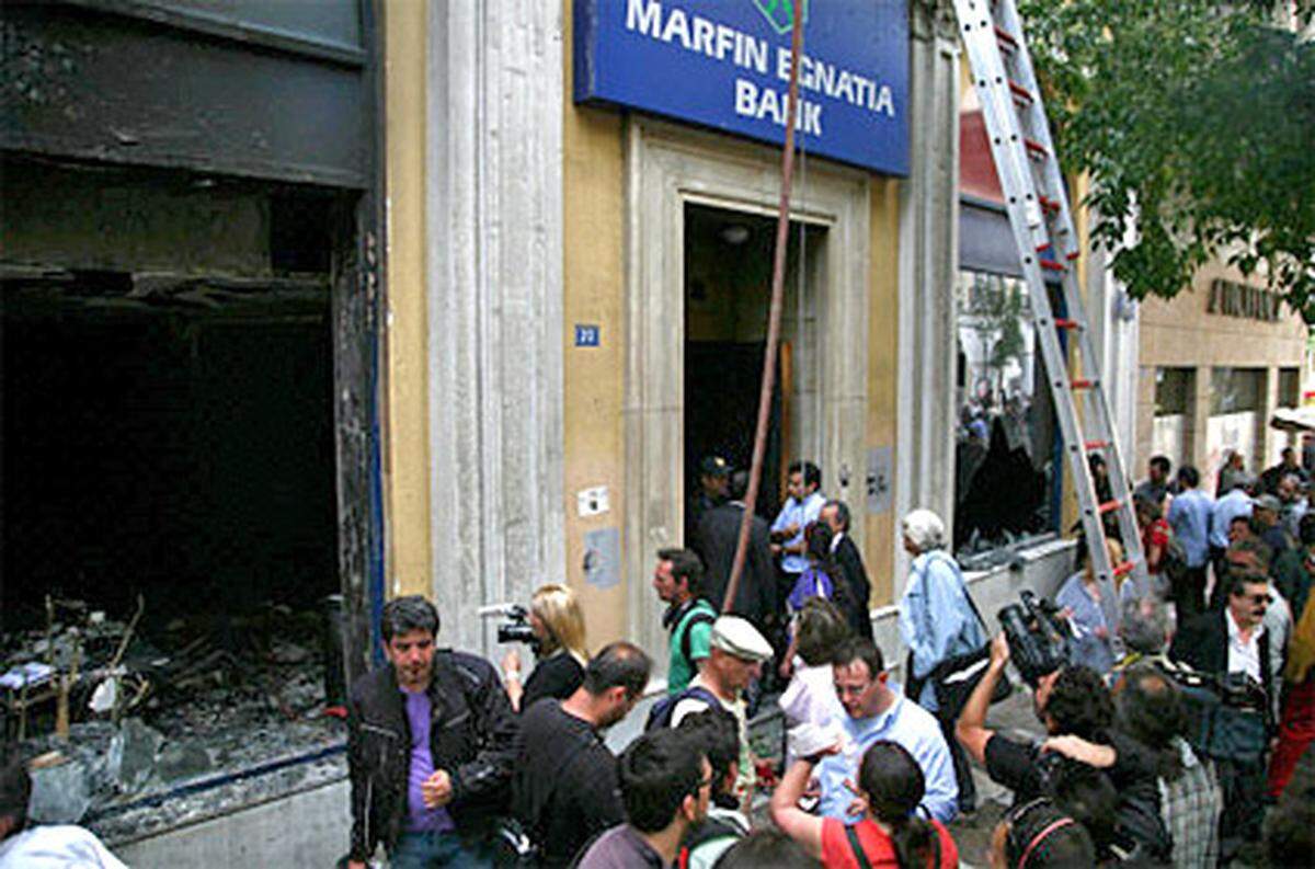 Zwei Frauen und ein Mann hatten im vierstöckigen Bankgebäude der Egnatia Bank versucht, sich vor den Flammen auf einen Balkon zu retten. Dabei brachen sie im raucherfüllten Treppenhaus zwischen drittem und viertem Geschoss ohnmächtig zusammen und wurden vom Feuer erfasst.