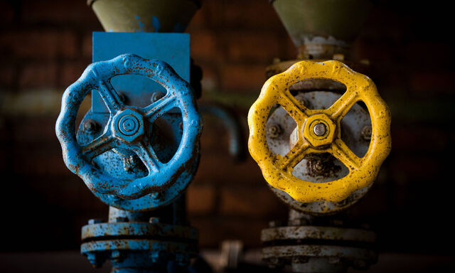 Gashahn, Oelhahn, in den Landesfarben der Ukraine. Dilemma Deutschlands wegen der Abhaengigkeit von russischem Gas und OeL