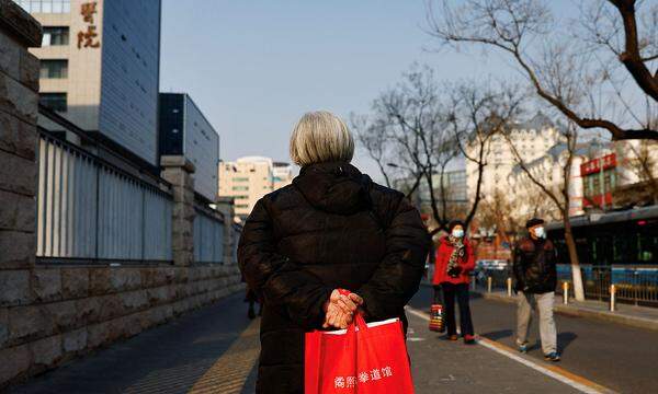 Elderly person walks near a hospital in Beijing