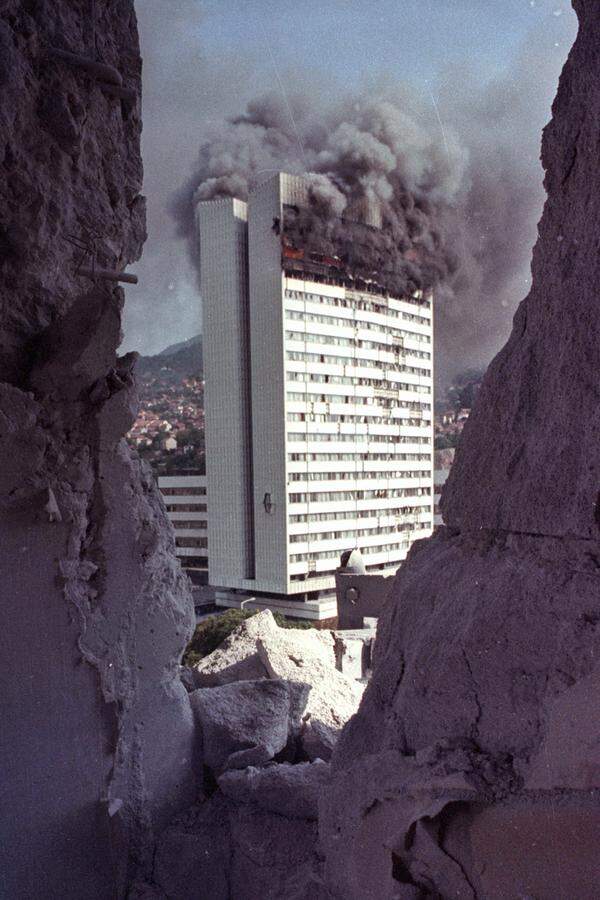 Das zweite Halbjahr 1992 und die erste Jahreshälfte 1993 bilden den Höhepunkt der Belagerung. Das Leben der Stadtbewohner findet in Kellern statt, die Wirtschaft bricht zusammen, das Wasser wird knapp, Strom gibt es kaum. Hinzu kommen Granatenangriffe: Im September 1993 sind in ganz Sarajevo 35.000 Gebäude zerstört und nahezu alle übrigen beschädigt. Die Nationalbibliothek mit tausenden Werken wird niedergebrannt, das Parlament schwer getroffen (Bild).